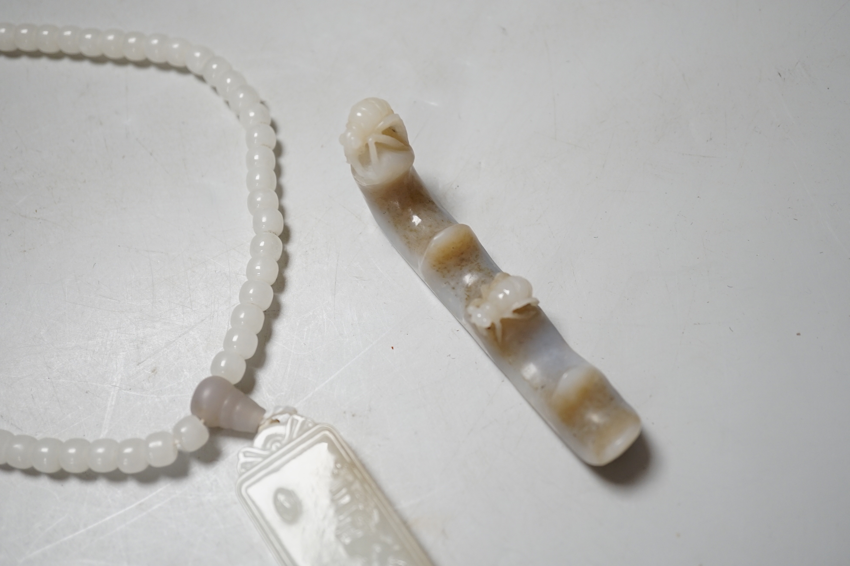 A Chinese white jade pendant and a jade brush rest